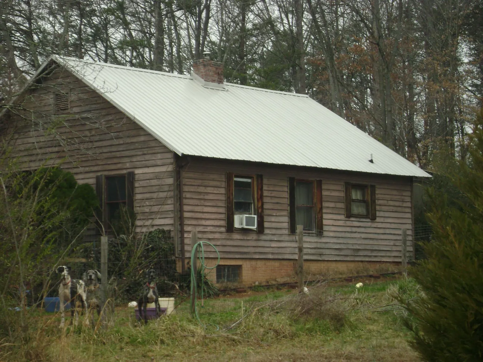 White metal roof on an old wood sided farmhouse, from a Metal Roof Installation job in Scotland